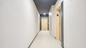 A hallway with white walls, a tiled floor, and doors numbered 1 and 2. - Apartamenty Sun & Snow Słoneczne Osiedle (Ustronie Morskie)