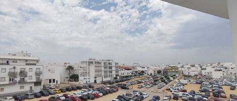 A parking lot with multiple cars and buildings in the background.