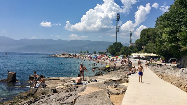 A beach with rocky terrain, a concrete walkway, and a clear blue sky. - Luxury apartment Ivone with balcony (Rijeka)
