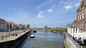 A canal with boats, a stone wall, and buildings on either side.