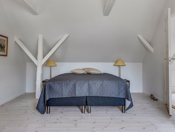 A bedroom with a bed, two bedside lamps, a framed picture on the wall, and a wooden floor. - "Constance" - 23km from the sea by Interhome (Ribe)