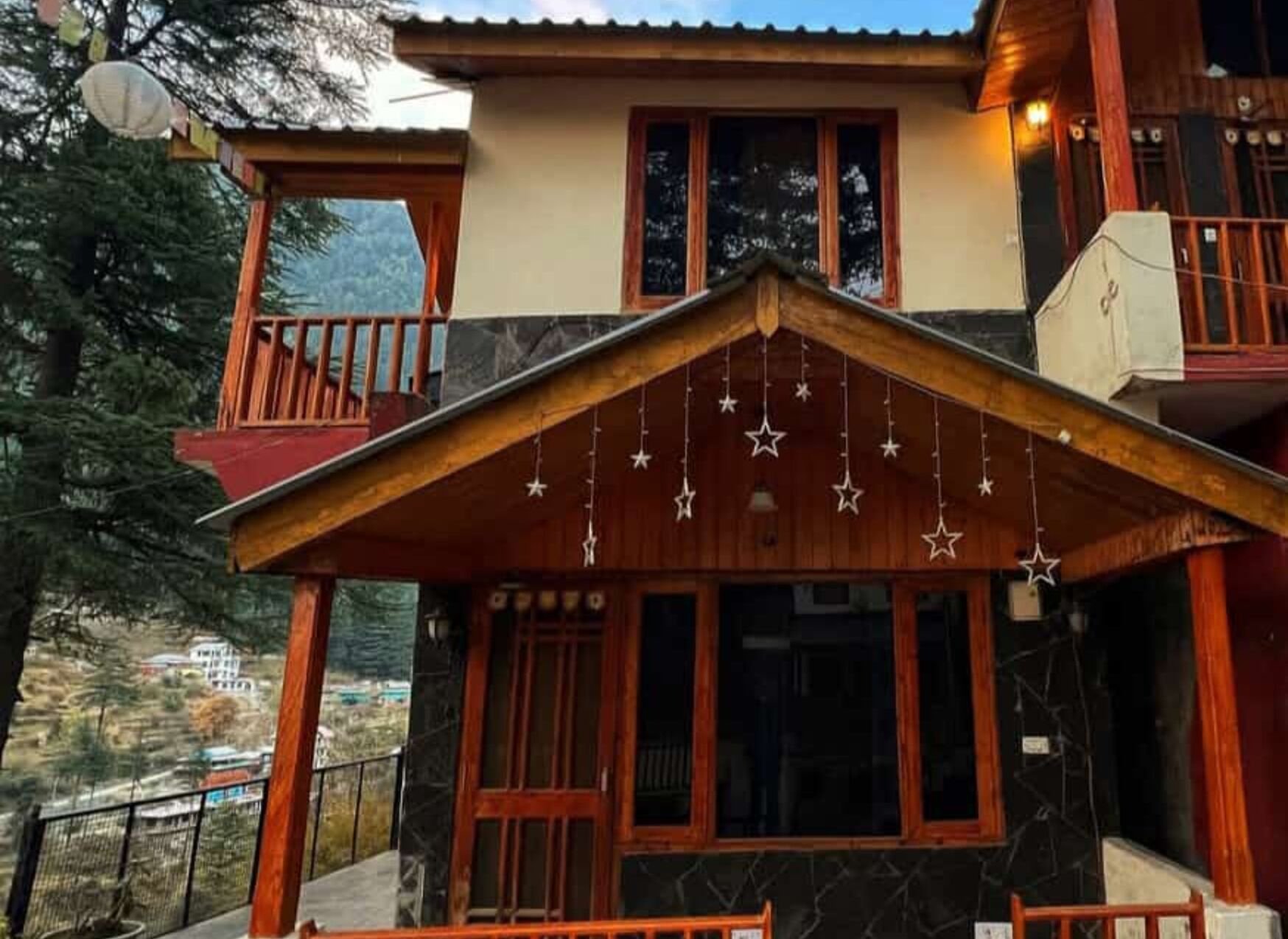 A two-story building with a wooden balcony and a covered entrance area.