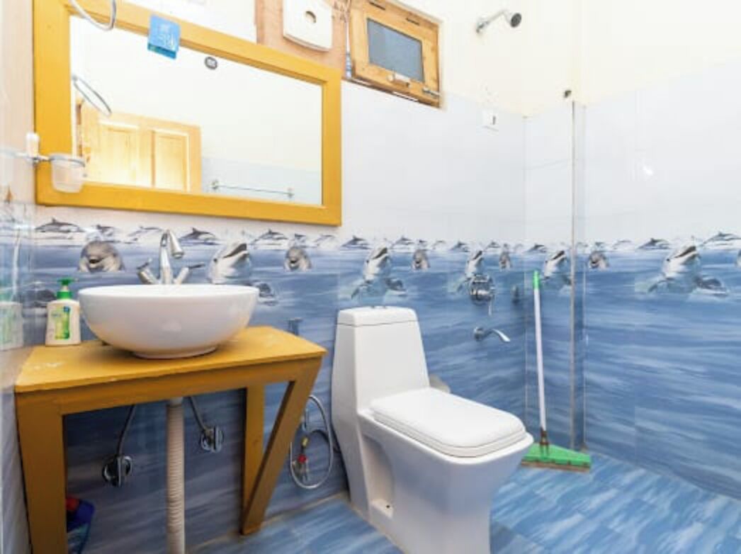 A bathroom with a large sink, toilet, and a mirror above the sink.