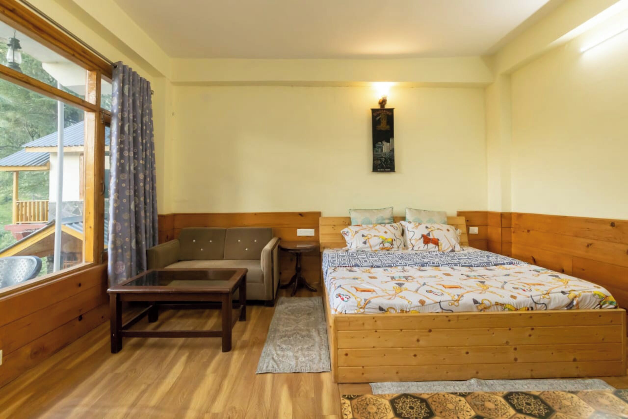 Ein Schlafzimmer mit einem hölzernen Bett, einer Couch, einem kleinen Tisch und einem Fenster mit Vorhängen.