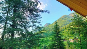 Un paisaje montañoso con bosques densos y algunos edificios.