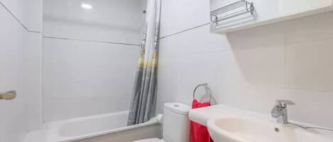 A bathroom with a bathtub, toilet, and sink.