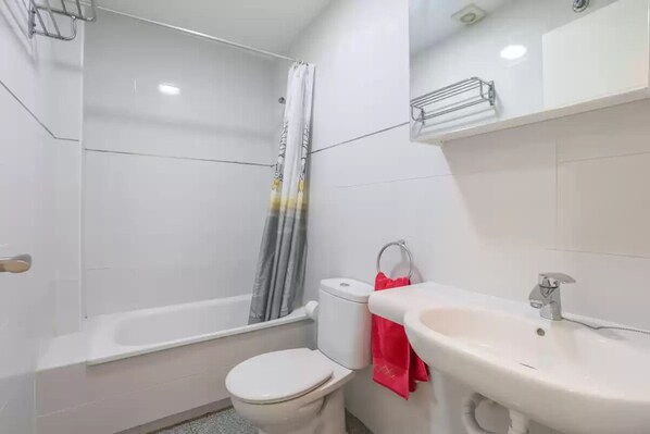 Une salle de bain avec une baignoire, des toilettes et un lavabo.
