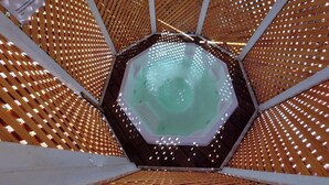 Ein sechseckiger Whirlpool, umgeben von einer Holzkonstruktion.
