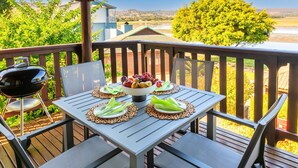 Eine Terrasse mit Esstisch und Stühlen, mit Blick auf eine schöne Landschaft.