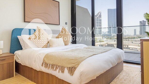 A modern bedroom with a large bed, a view of the city, and a balcony. - 336 -Bloomfields Stylish 1BR In Al Maryah Vista (Abu Dabi)
