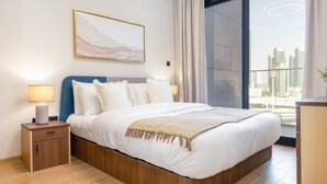 Ein modernes Schlafzimmer mit einem großen Bett, einem Nachttisch, einer Wandlampe und einem Blick auf die Stadt durch ein großes Fenster.
