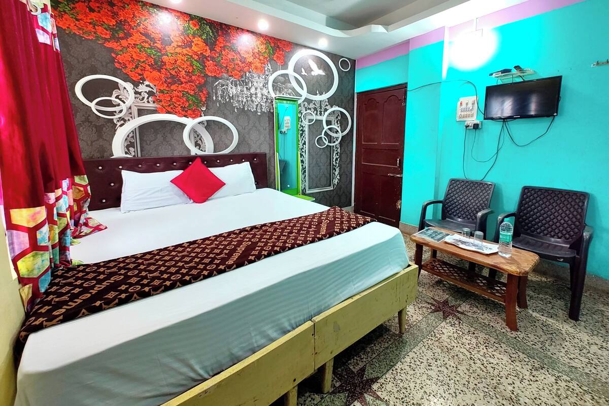 A hotel room with a bed, a TV, a desk, and a chair.