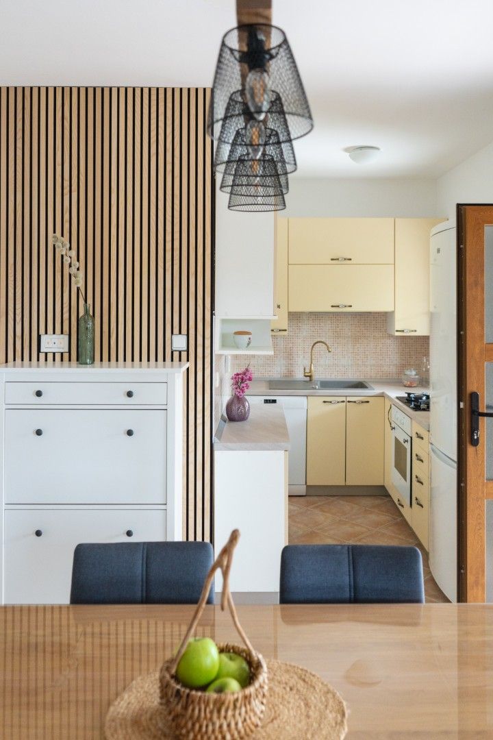 Una cucina moderna con carta da parati a righe, un tavolo da pranzo con sedie e un lampadario.