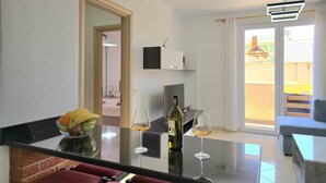 A modern kitchen with a dining area, a large window, and a view of the outside. - Sea View Holiday Apartment 073 (Durres)