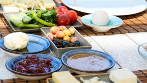 A table set with various dishes including vegetables, eggs, and cheese, suggesting a meal setup. - Deniz Evi (Cesme)