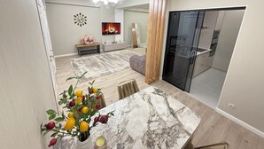 Un salon moderne avec une table à manger en marbre, un grand miroir et une cheminée.