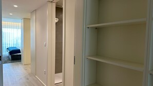 Un couloir donnant sur une chambre avec un lit, un placard et une salle de bain.