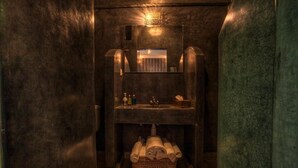 A small, dimly lit bathroom with a single sink, a mirror, and a towel rack. - Le Matin, Riad 111 and Spa (Marrakech)