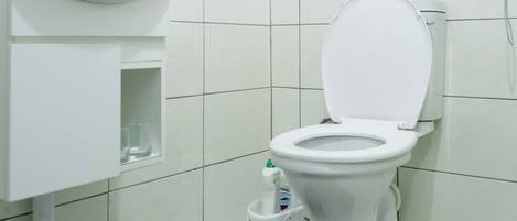 A modern bathroom with a white toilet, a sink, and a mirror.