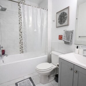 Une salle de bain moderne équipée d’une baignoire, de toilettes et d’un lavabo.