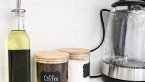 A kitchen counter with a bottle of olive oil, two jars labeled 'Coffee', and a coffee maker. - ReeseStreetUnit2inPhilly. (Philadelphia)