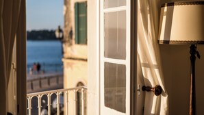 A room with a view of a body of water, a balcony with a railing, and a lamp. - Casa Milonopoulos by Konnect, Studio & Main House (Corfu)