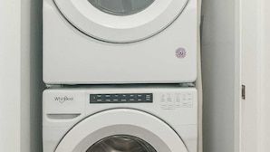 A stacked washer and dryer unit in a laundry room. - Stylish 2BR/2BA near TempleU with Wi-Fi, in-unit laundry & parking (Philadelphia)