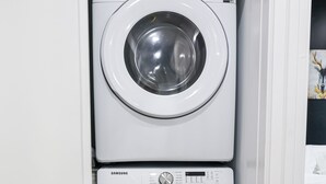 A white laundry room with two Samsung front-loading washing machines. - 1Bed/1Bath_KingBed Central+W/D+WIFi (Philadelphia)