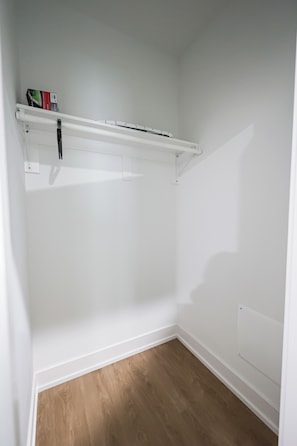 A small, empty room with white walls, a wooden floor, and a white ceiling with a light fixture. - 1Bed/1Bath_KingBed Central+W/D+WIFi (Philadelphia)