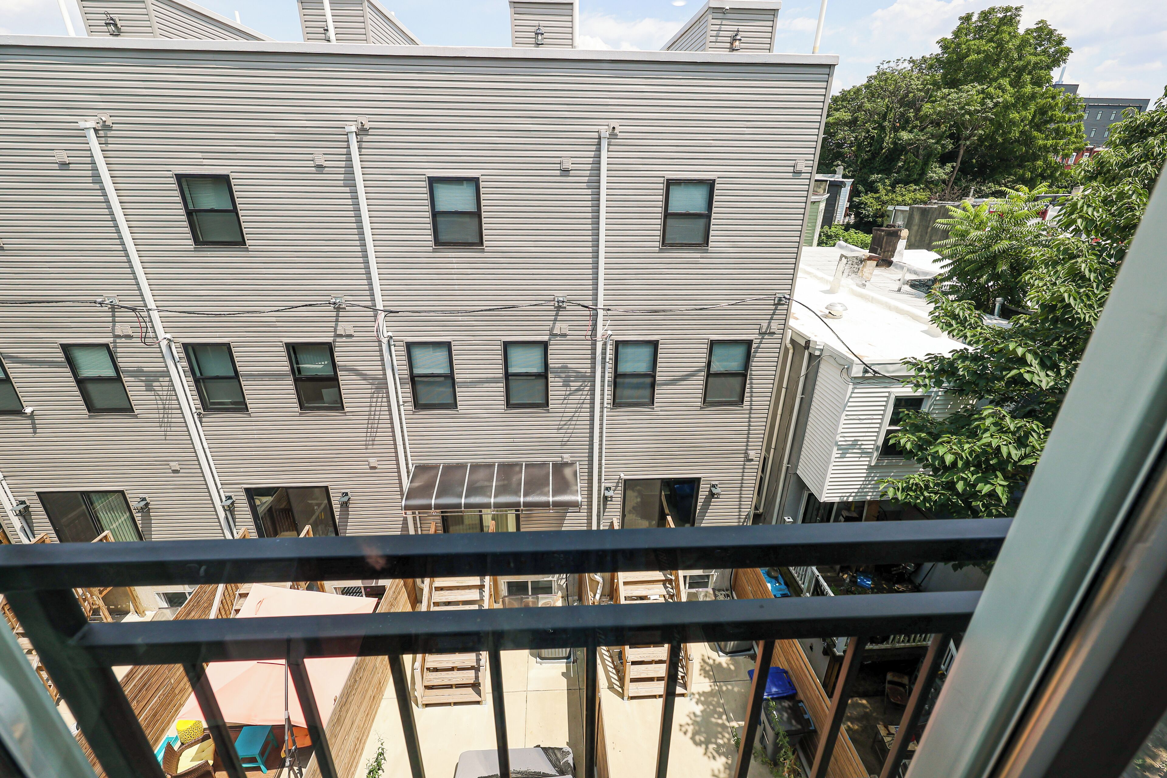 A multi-story building with a flat roof, multiple windows, and visible utility lines.