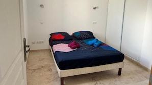 A bedroom with a bed, an air conditioning unit, and a wardrobe. - LA MAISON DU SOLEIL MAGNIFICENT NEW EQUIPPED T3 IN PORTICCIO (Grosseto-Prugna)