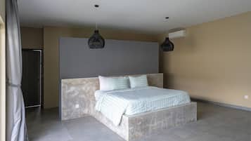 A modern bedroom with a large bed, a marble headboard, and pendant lighting.