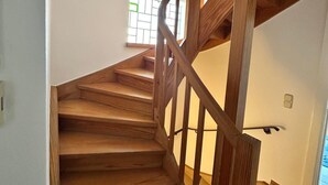 A wooden staircase with a handrail, leading to an upper floor. - Large apartment in the center of Plön within walking distance to the lake/shops. Children's room (Plön)