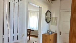 A cozy room with a wooden ceiling, a white door, a wooden cabinet, and a brown sofa with cushions. - Large apartment in the center of Plön within walking distance to the lake/shops. Children's room (Plön)