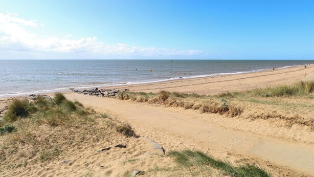 A beach with a clear sky, sandy shore, and a few scattered rocks. - Bankside Cottage (King's Lynn)