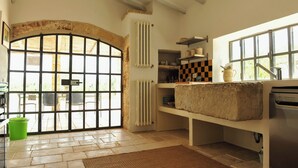 A kitchen with a large window, a radiator, and a built-in bench. - Pool, relax, and Olives at Masseria Don Tommaso and its guesthouse (Specchia)