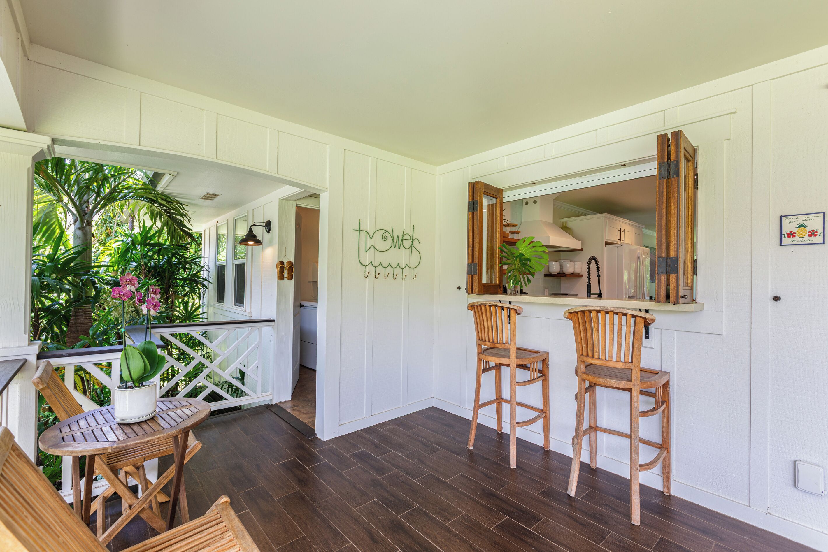 A kitchen with wooden chairs, a bar area, and a view of the outdoors.