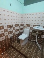 Un baño pequeño con inodoro, lavamanos y ducha.
