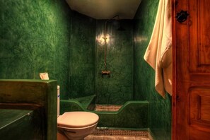 A bathroom with a green marble wall, a wooden door, and a white towel hanging on the door. - Calla Lilly, Riad 111 and Spa (Marrakech)
