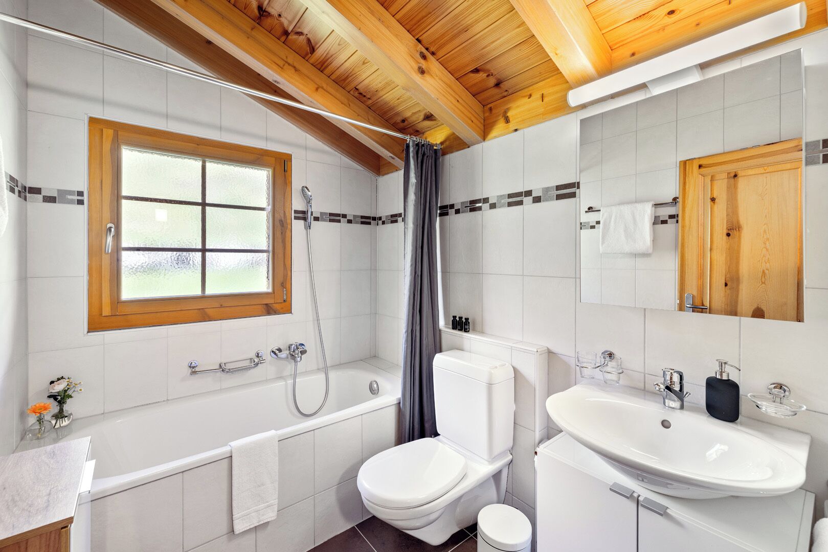 A modern bathroom with a bathtub, toilet, and sink.