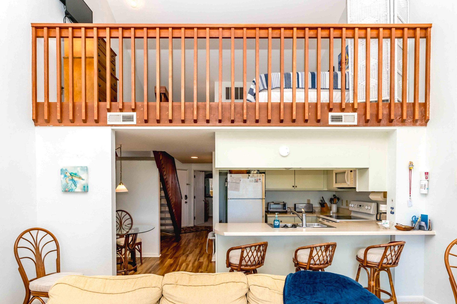 A compact living space with a kitchen, dining area, and a staircase leading to an upper level.