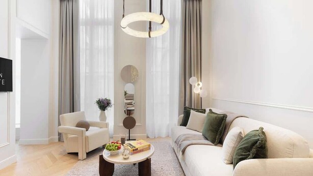 A modern living room with a sofa, armchair, coffee table, and decorative items.