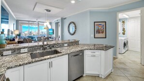 A modern kitchen with granite countertops, white cabinetry, and a built-in dishwasher. - REGATTA - ENJOY GULF AND BAY VIEWS! (Naples)