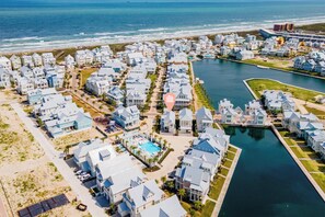 A coastal residential area with houses, a marina, and a swimming pool. - Beach home in CS South with access to 20+ resort like amenities (Port Aransas)