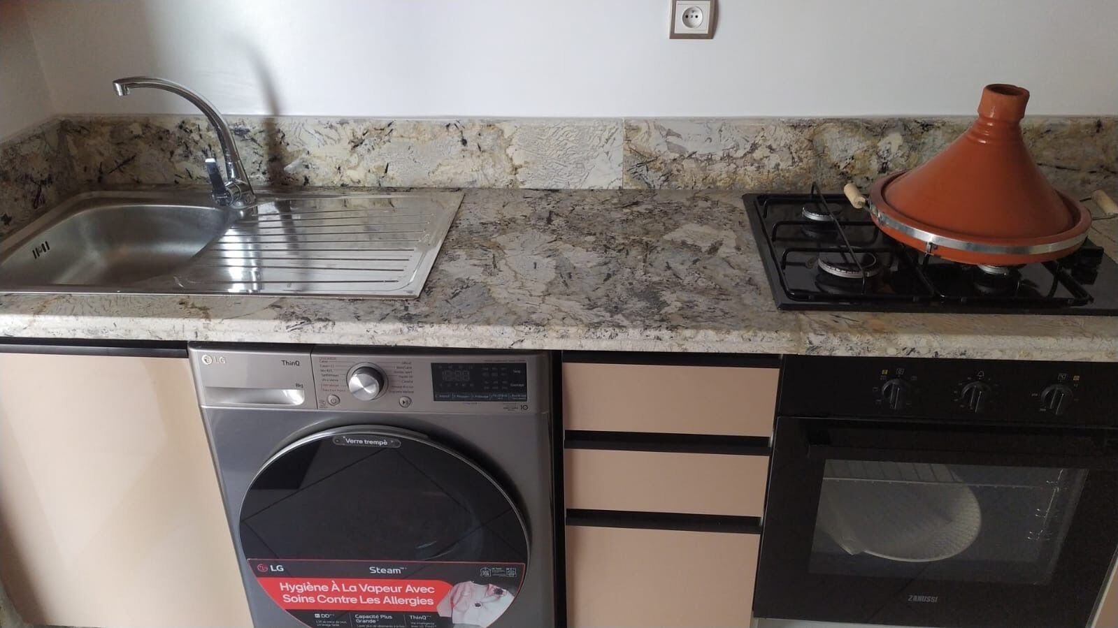 Una cocina equipada con lavadora, estufa y lavavajillas.