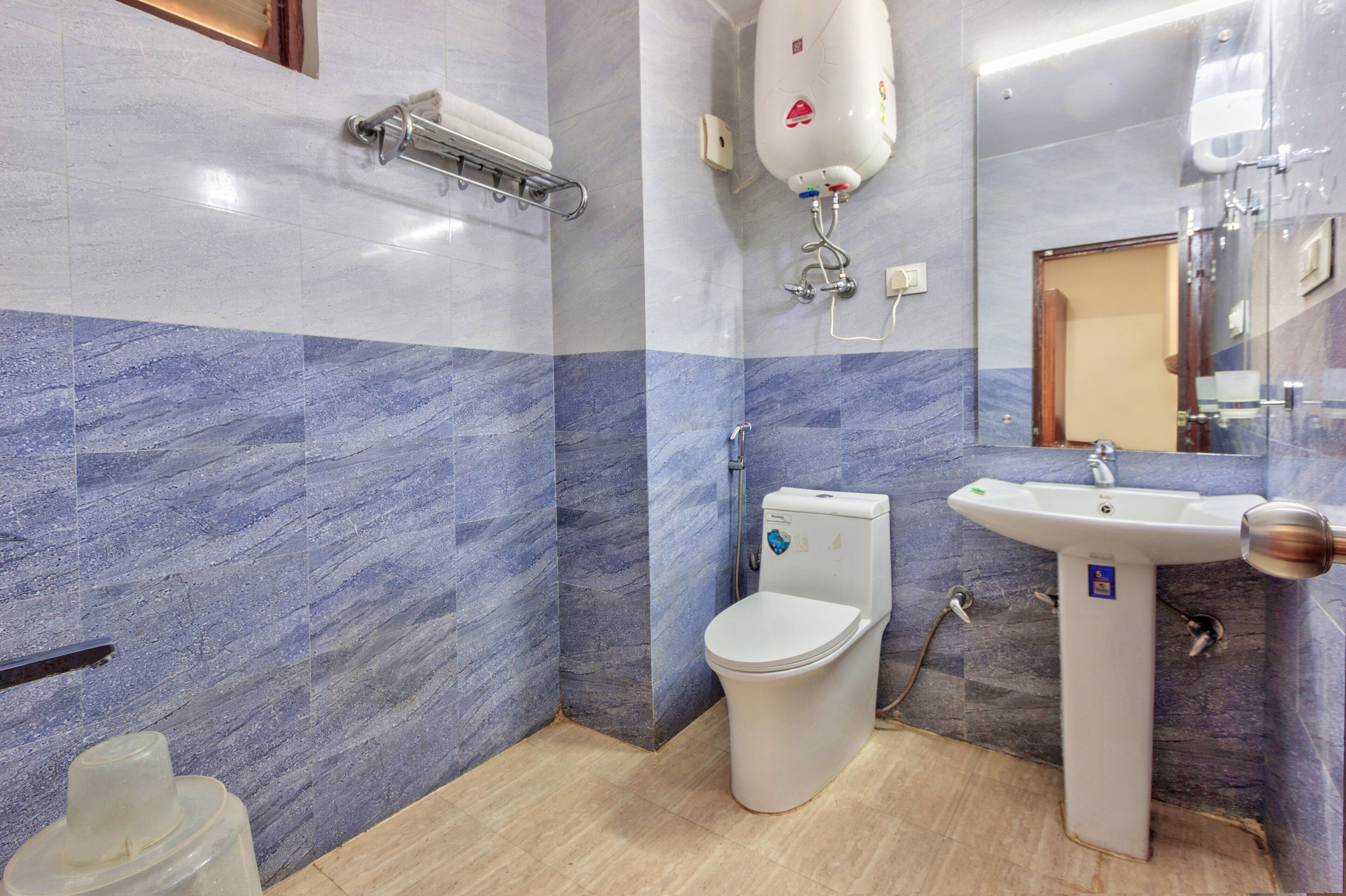 Et moderne badeværelse med toilet, håndvask og bruser.