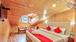 A wooden-paneled room with a bed, a desk, and a chair. - The mount Heaven Hotel  Vijayant (Manali)