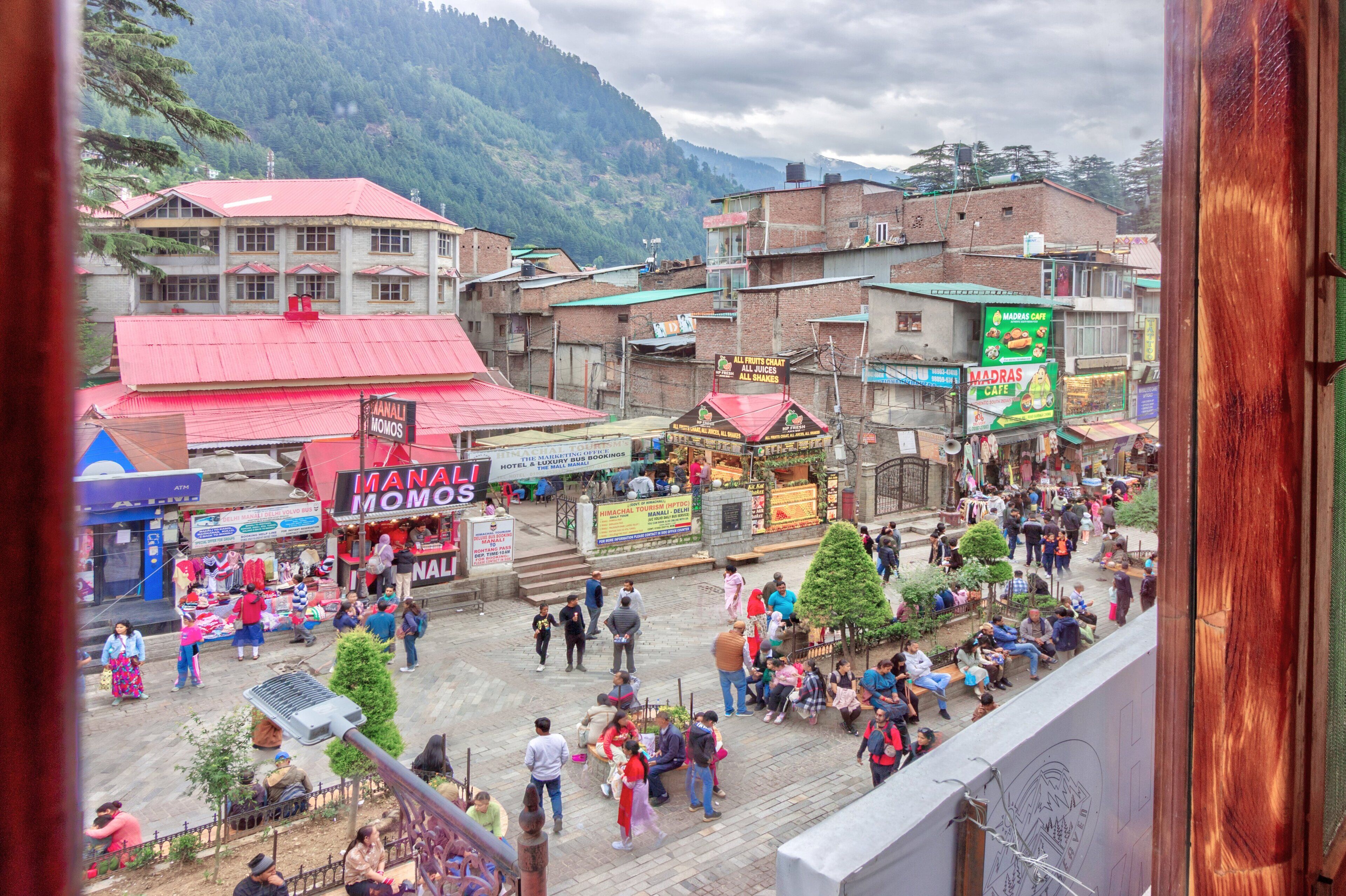 A bustling market area with various shops and stalls, including a prominent 'Madras Cafe'.