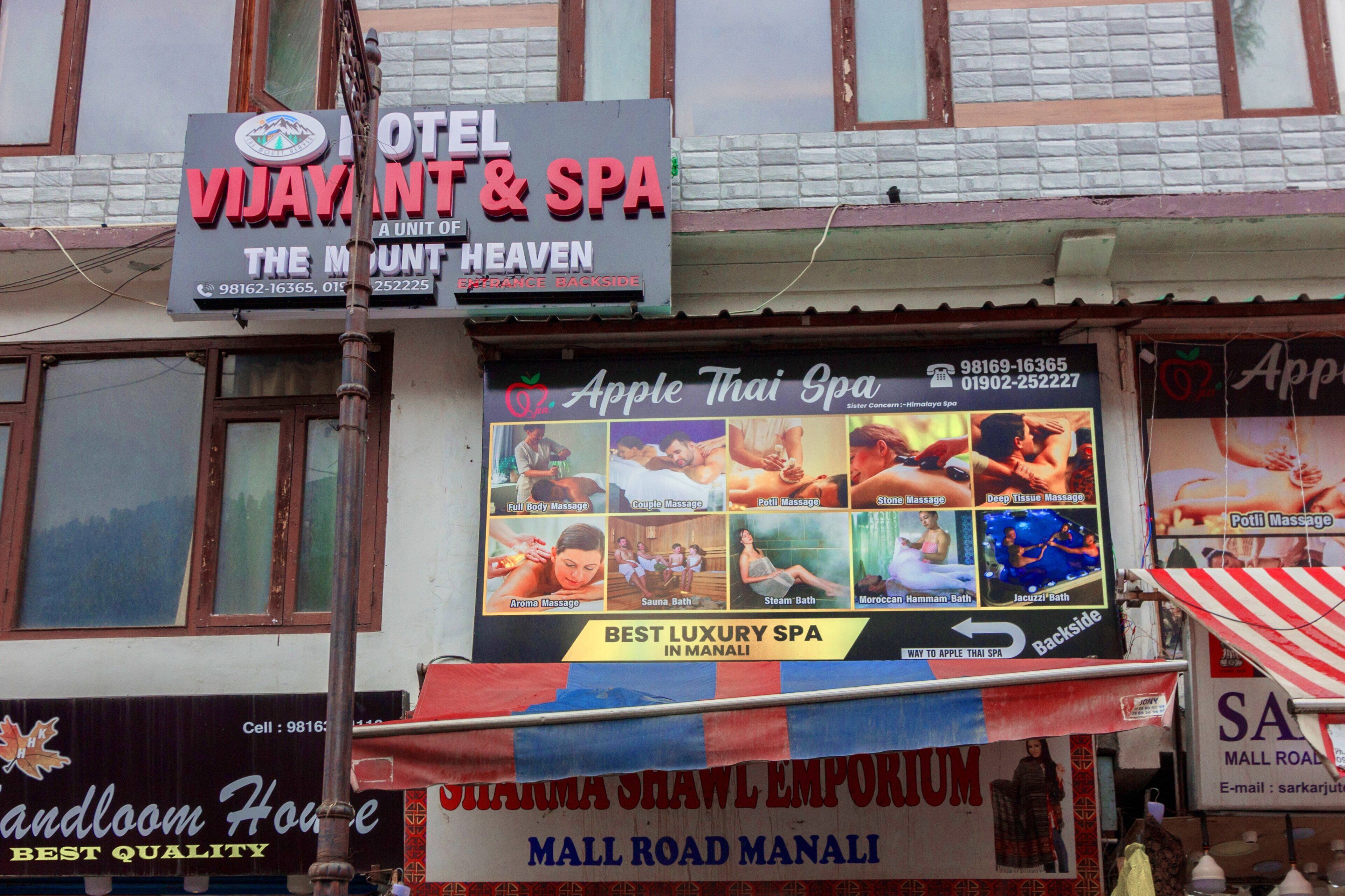 A hotel with a sign for 'Hotel Vijayant & Spa' and 'Apple Thai Spa'.