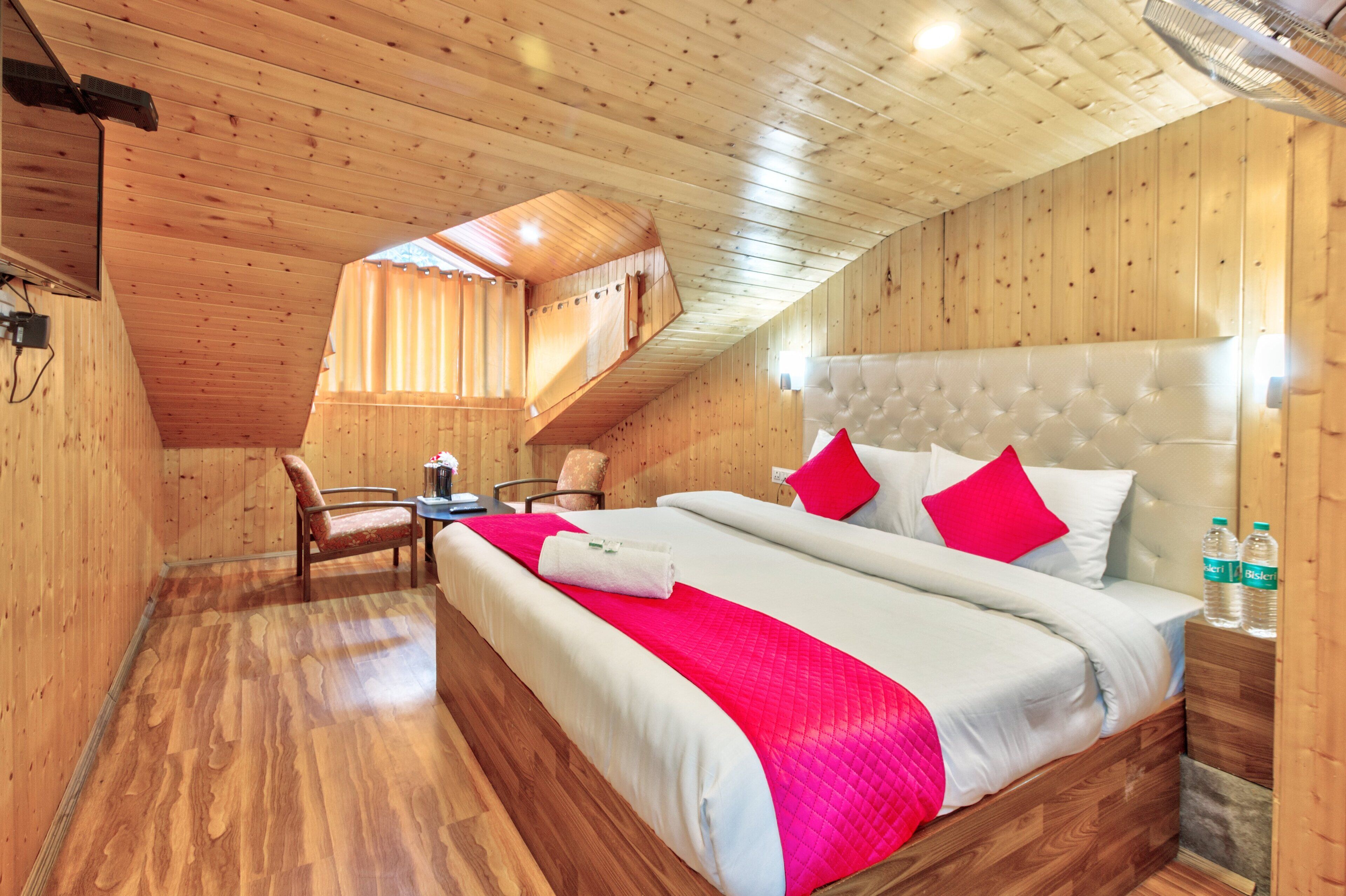 Una habitación de madera con una cama, una silla y una mesa.